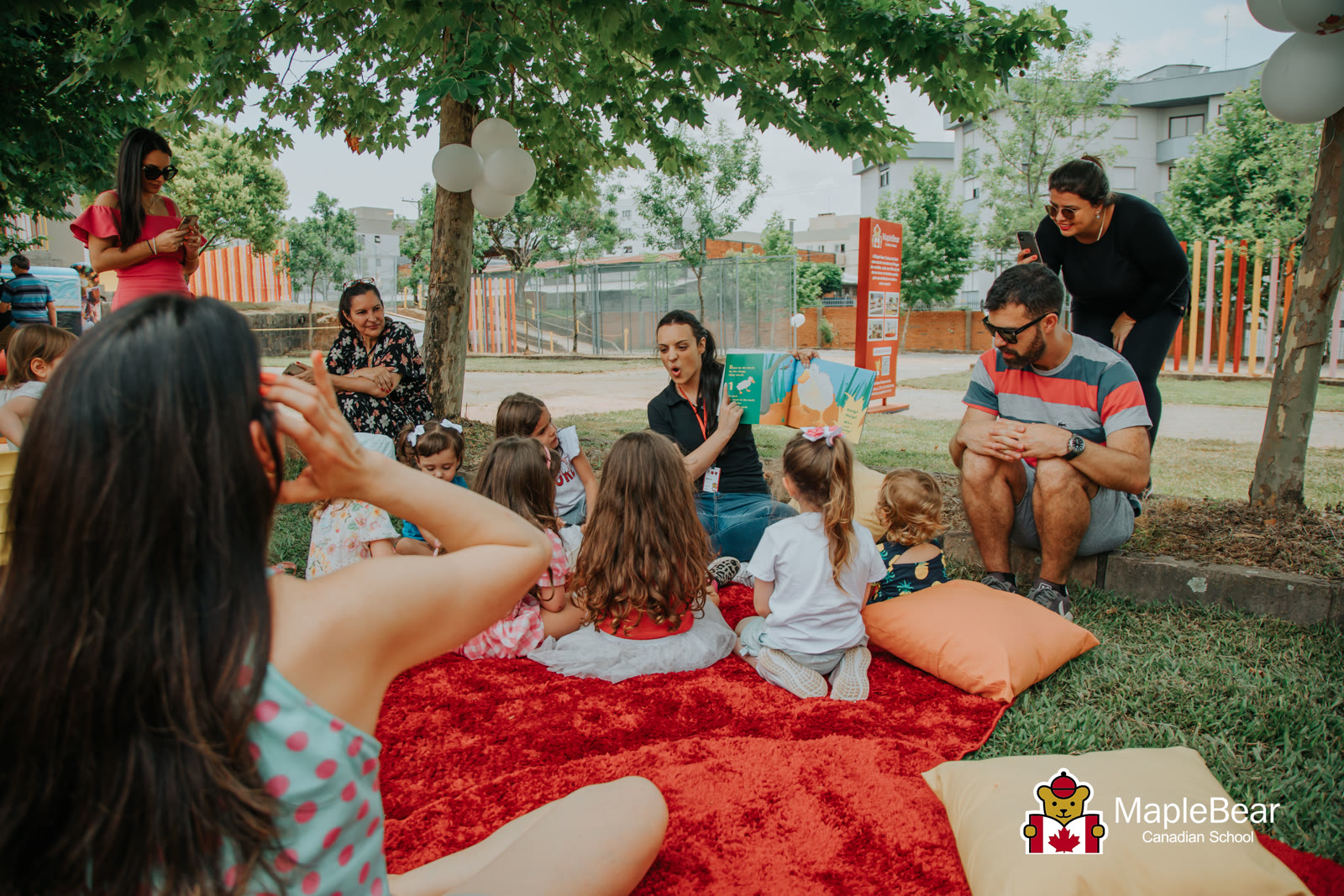 Contação de histórias ao ar livre com crianças e famílias na Maple Bear Caxias