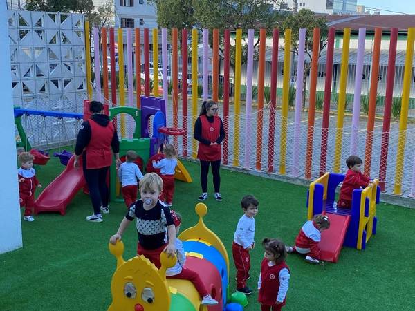 Parquinho colorido dos pequenos, com escorregador e grama sintética
