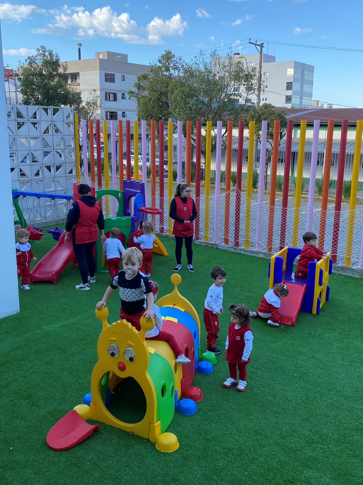 Crianças do Bear Care brincando no parquinho colorido