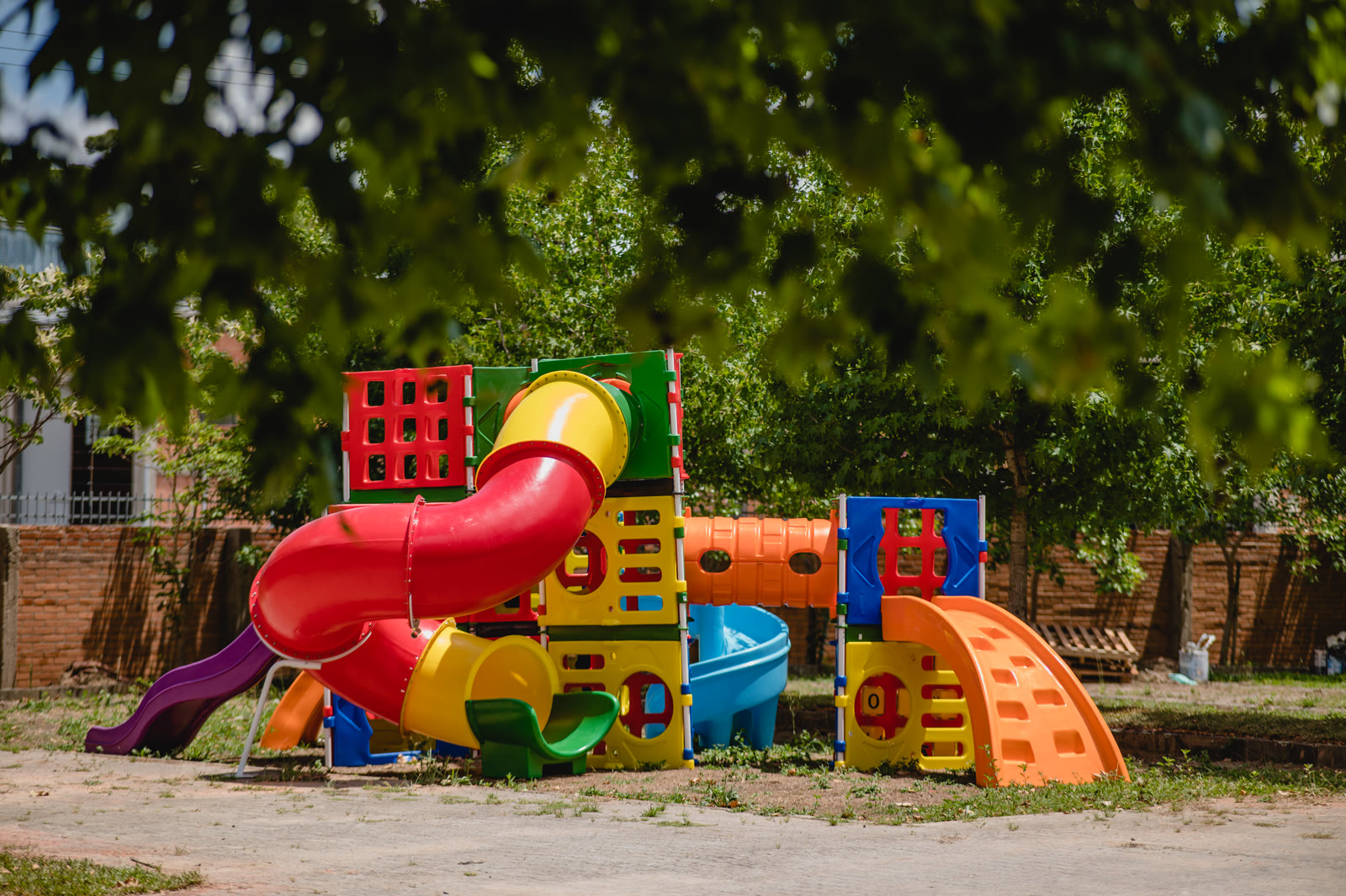 Pátio externo com estrutura de playground colorida