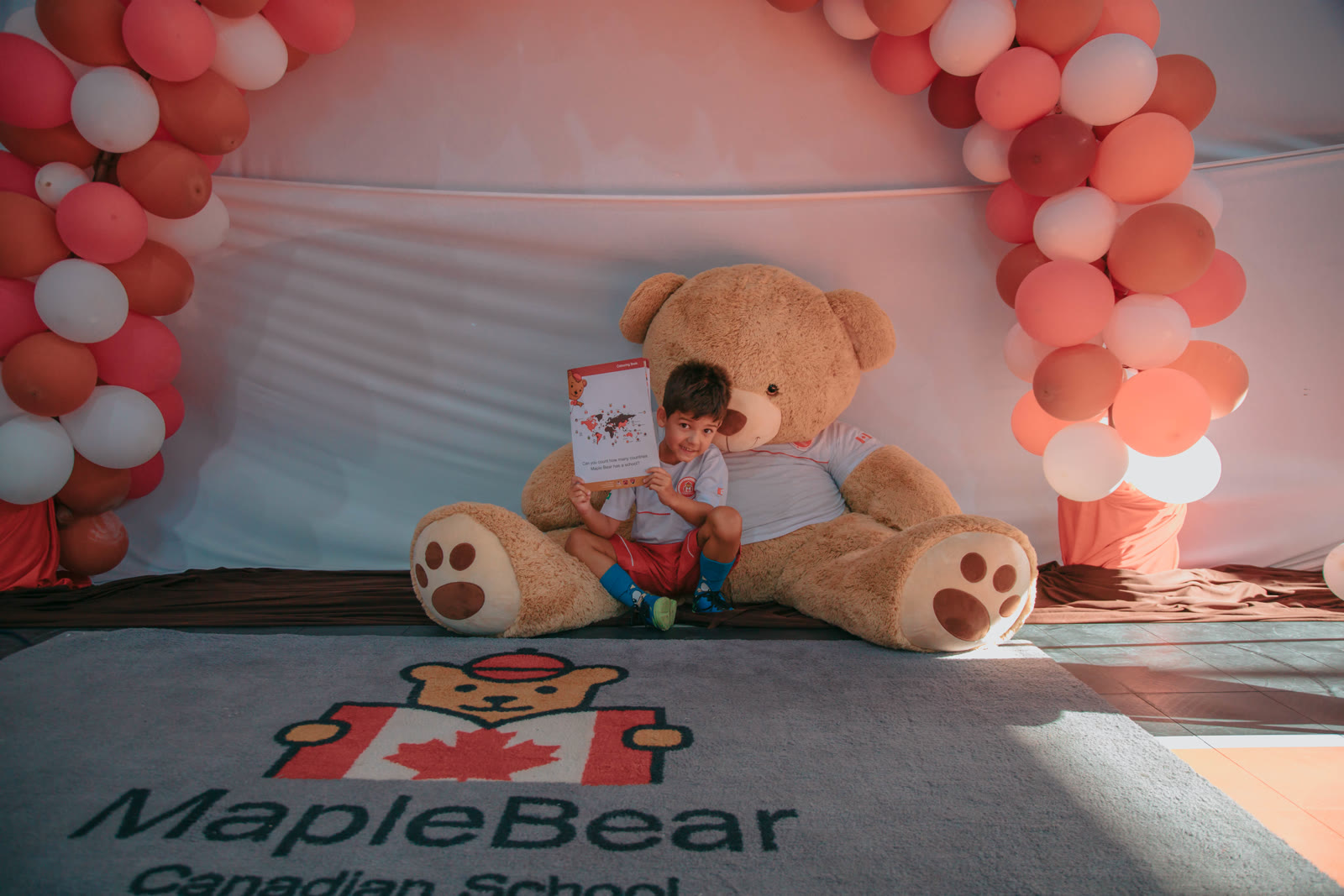 Criança com o ursinho Chinook em celebração Maple Bear